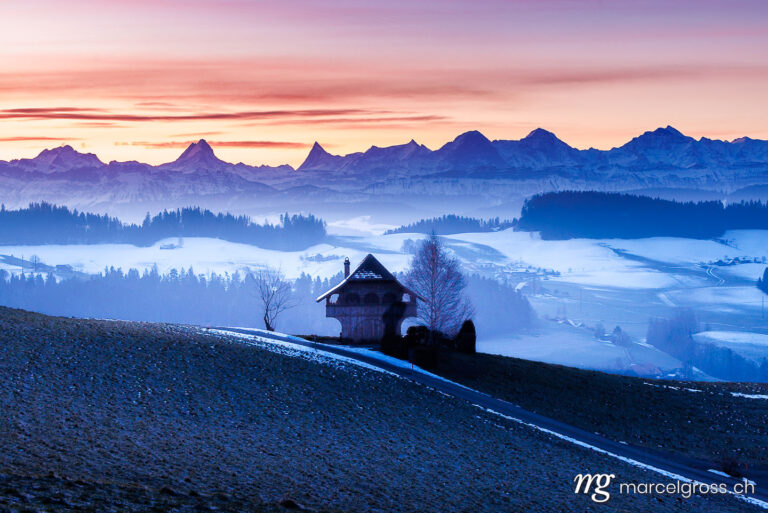 Emmental winter pictures. Emmentaler Spycher in winter in front of the Bernese Alps. Marcel Gross Photography